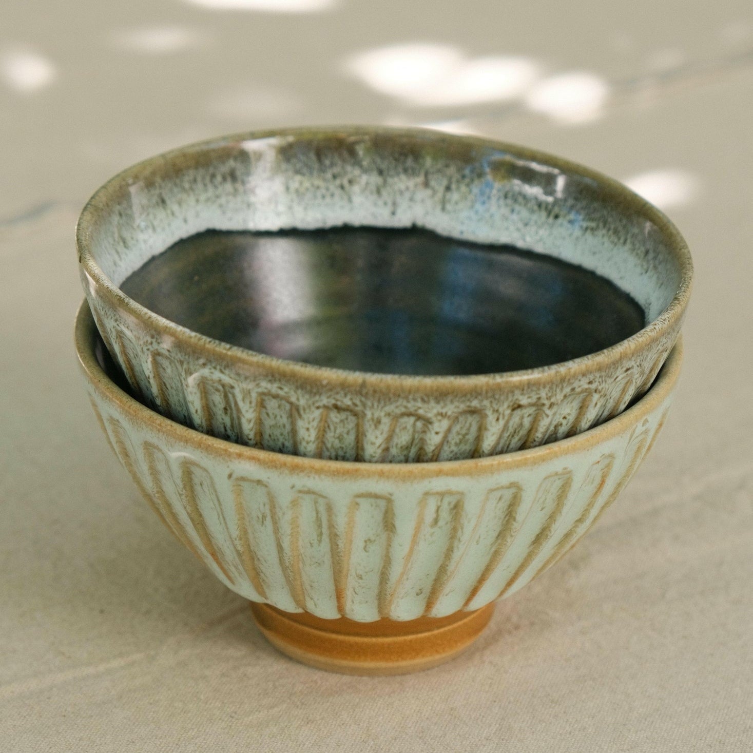 MANTRA LIVING two hand-fluted ceramic bowls stacked, showing the ridged sides and speckled hand-glazed finish. #Color_Antique Slate