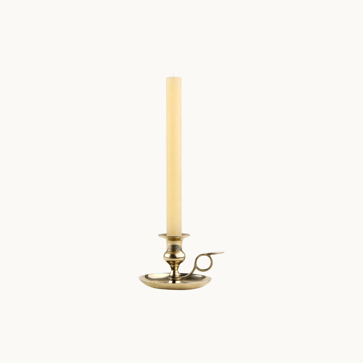 Mantra Living Frosted Dinner Candle in honey, a warm ivory taper in a brass chamberstick holder. #Color_Honey