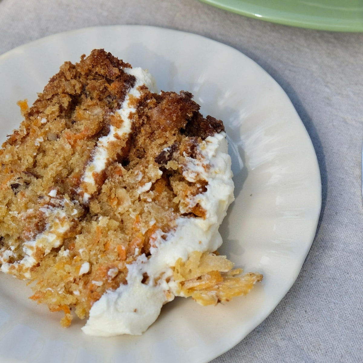 Mantra Living Daisy side plate in Almond holding a slice of carrot cake. #Color_Almond
