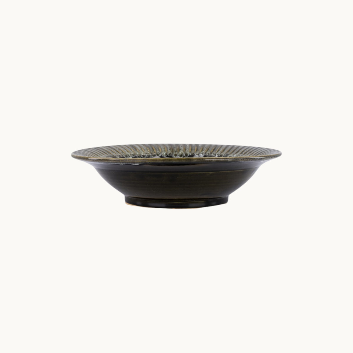 MANTRA LIVING handcrafted ceramic fluted centerpiece bowl in a dark glossy glaze, side view.