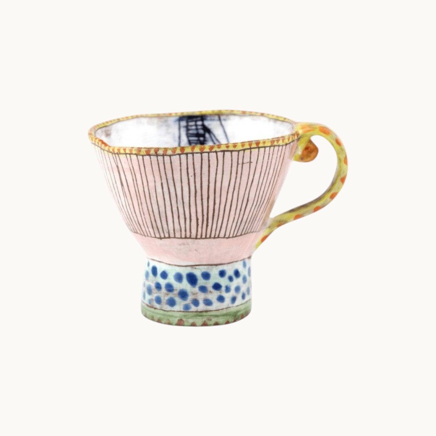 MANTRA LIVING Isabella tea cup with hand-painted pastel stripes, blue dots, and a unique patterned handle.