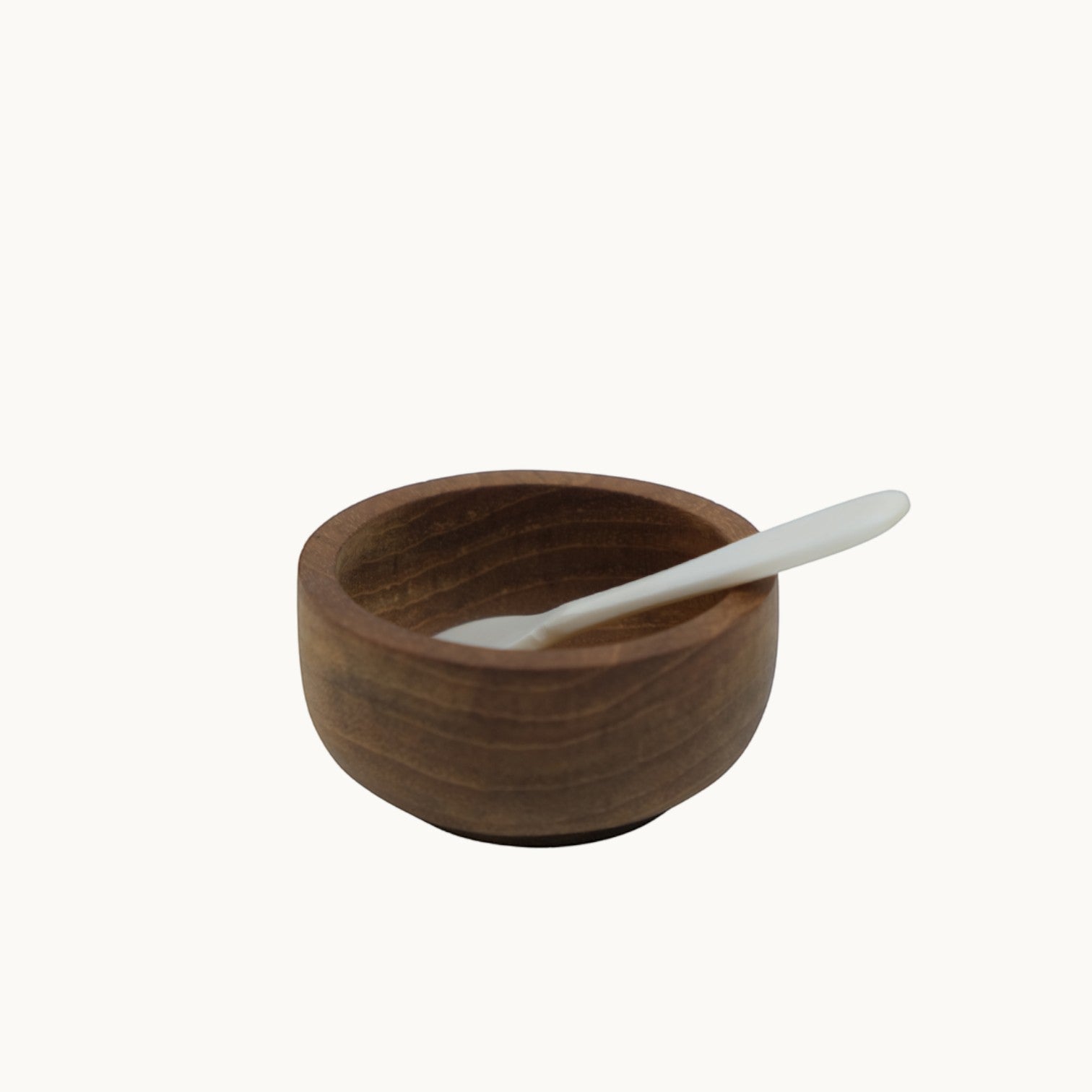 Mantra Living teak salt pinch pot in the small size with a bone salt spoon resting inside the bowl. #Size_Small