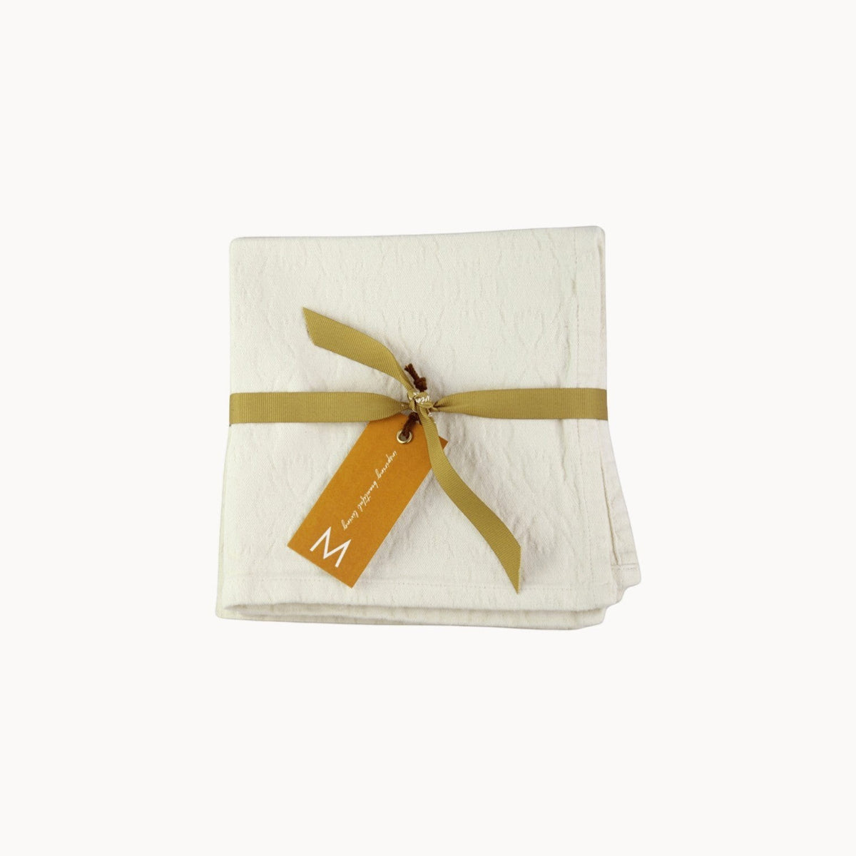 Mantra Living Hibiscus cotton napkins in vanilla, set of four folded jacquard napkins with a decorative ribbon tie. #Color_Vanilla