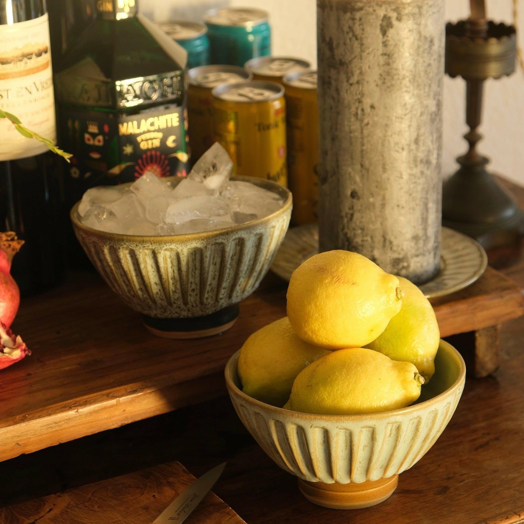 MANTRA LIVING fluted bowls on a drinks table, one holding ice and one holding lemons, beside bottles and mixers. #Color_Desert Oasis