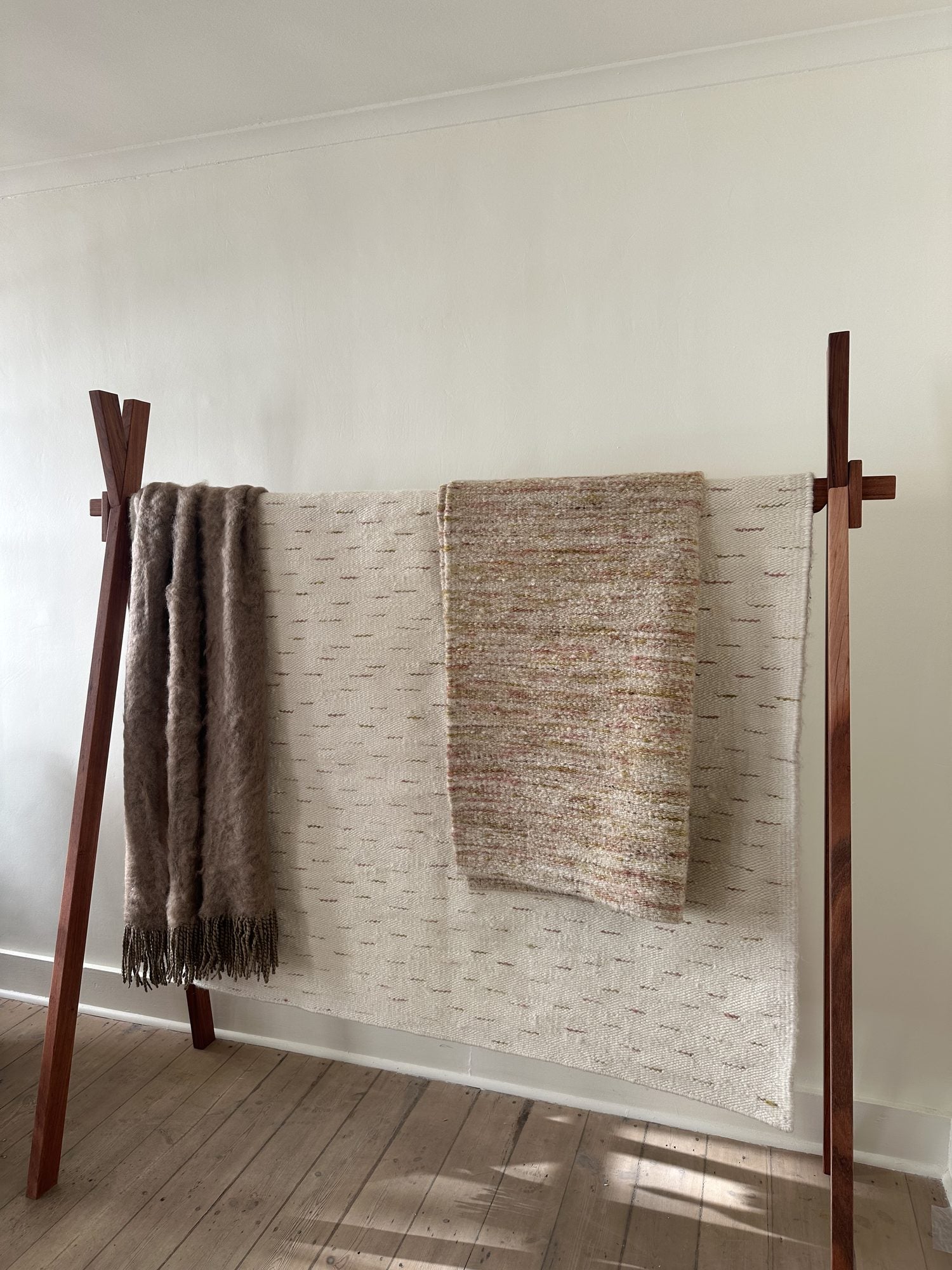 Mohair and woven throws hanging over a timber display rail