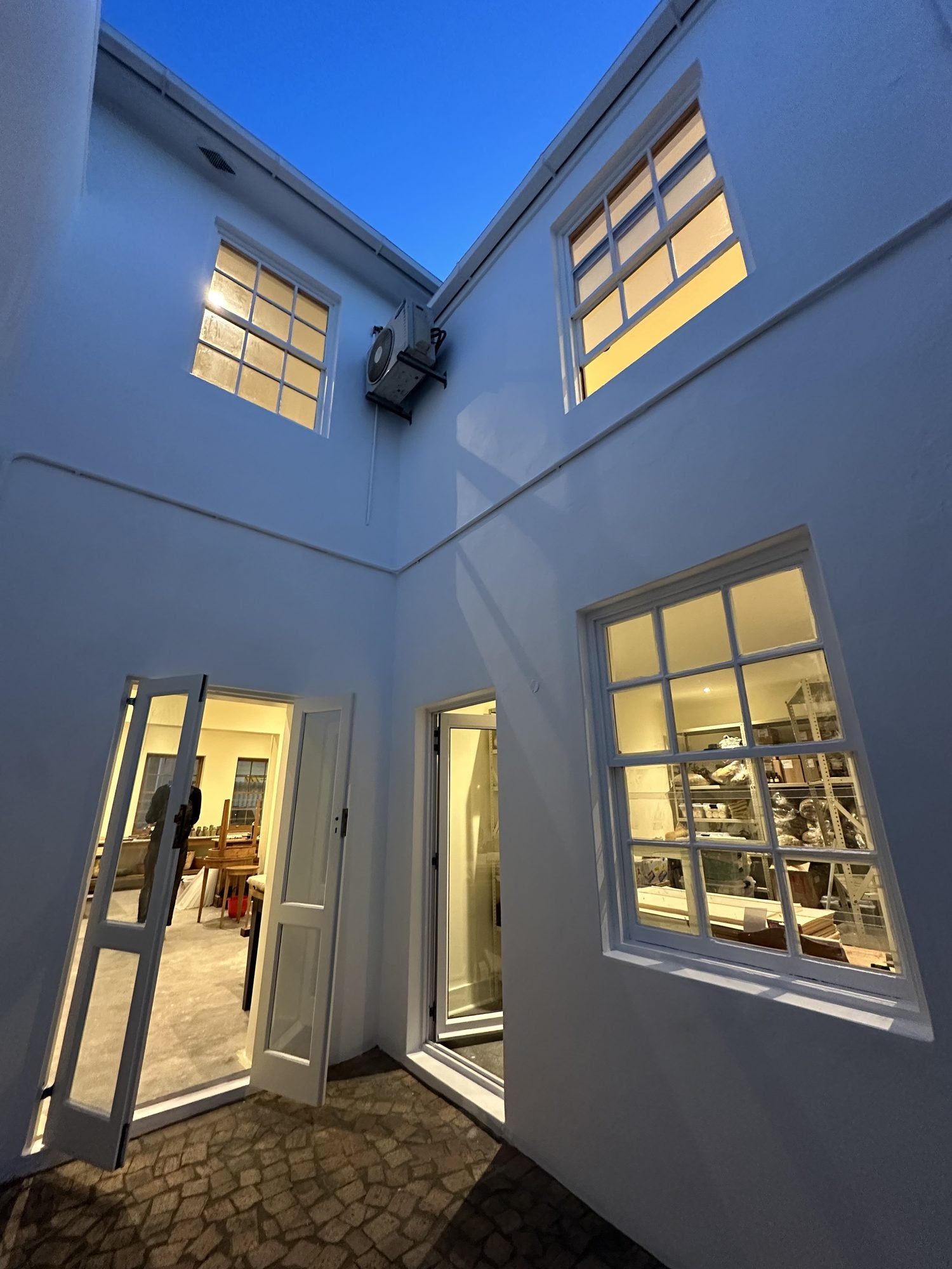 The courtyard at 8 Watson Street at dusk, windows lit from inside