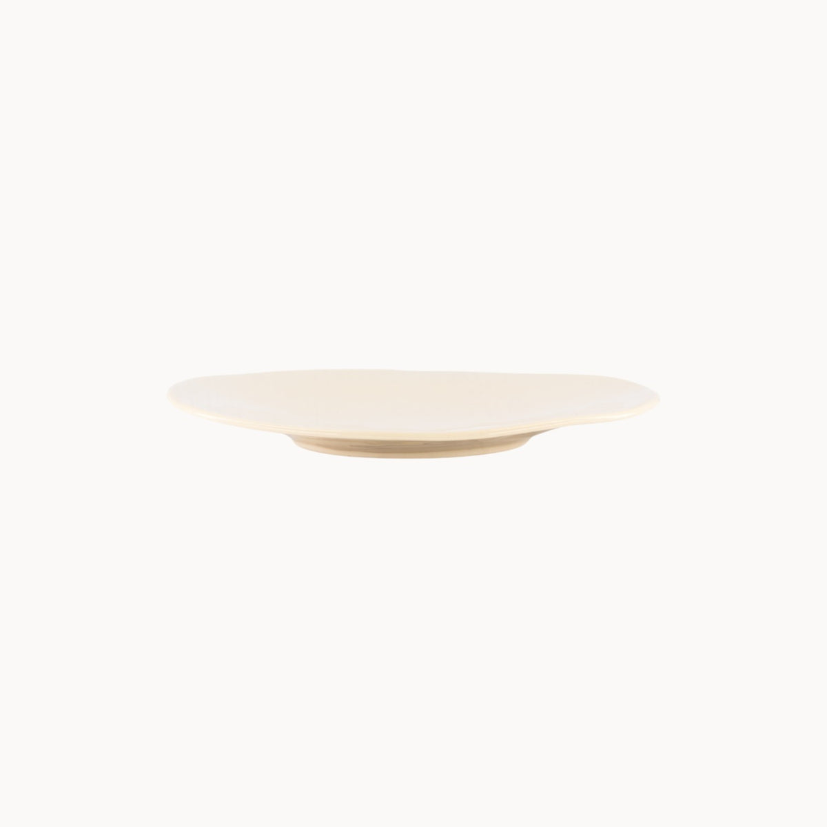Mantra Living Classic Stoneware presentation plate in Almond, hand-finished by Mervyn Gers, seen in profile. #Color_Almond