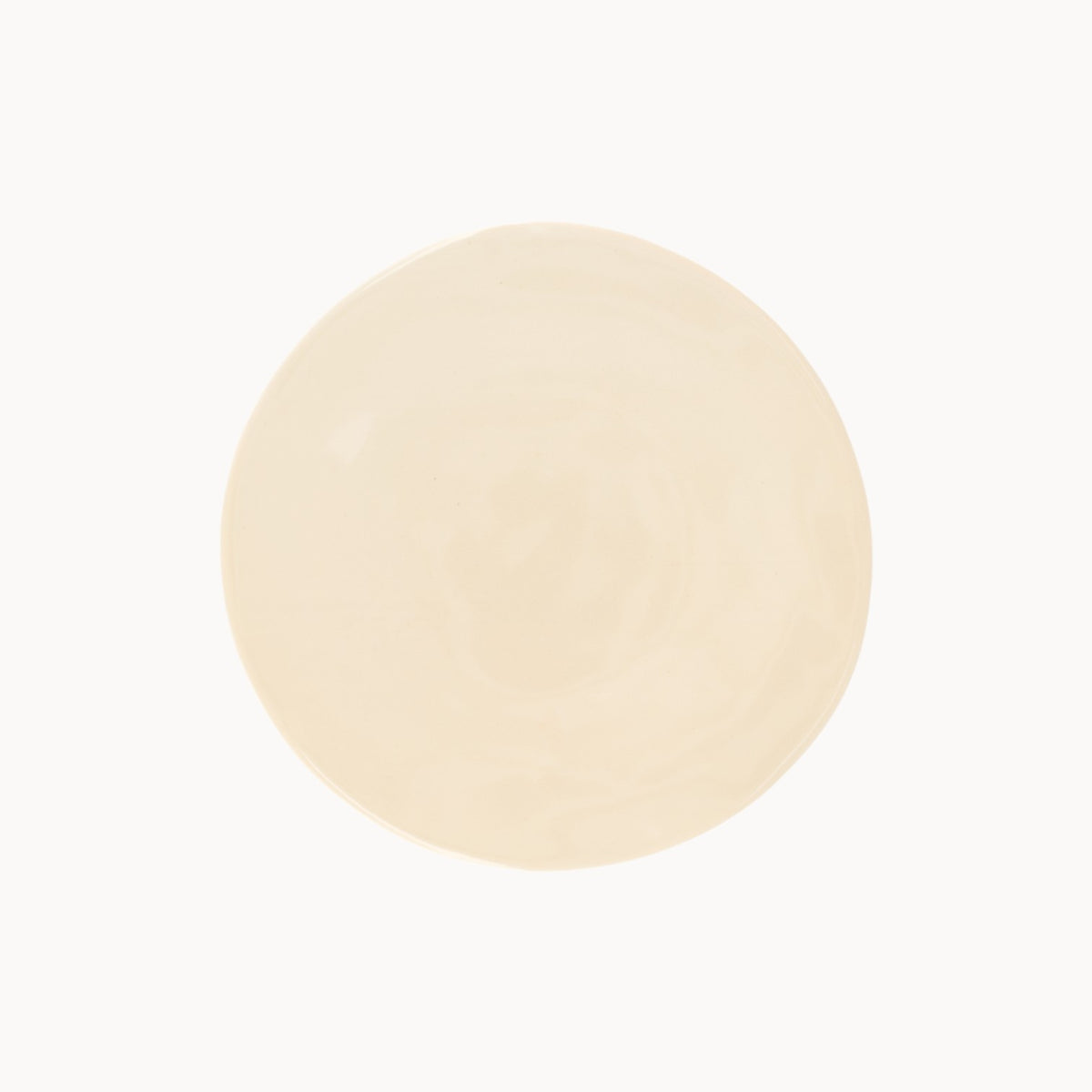Mantra Living Classic Stoneware presentation plate in Almond, seen from above with its round, organic-edged form. #Color_Almond