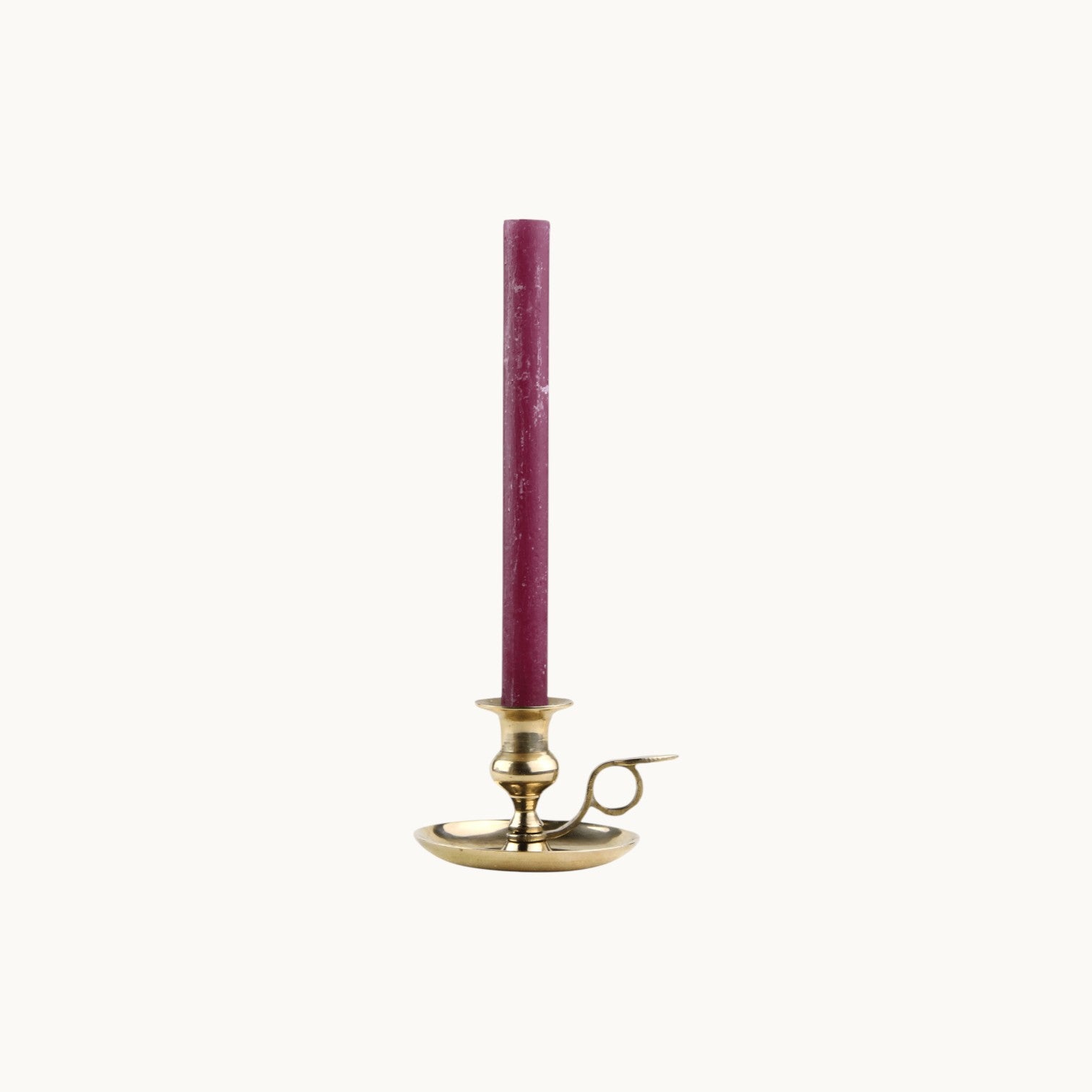 Mantra Living Frosted Dinner Candle in aubergine, a deep plum taper in a brass chamberstick holder. #Color_Aubergine