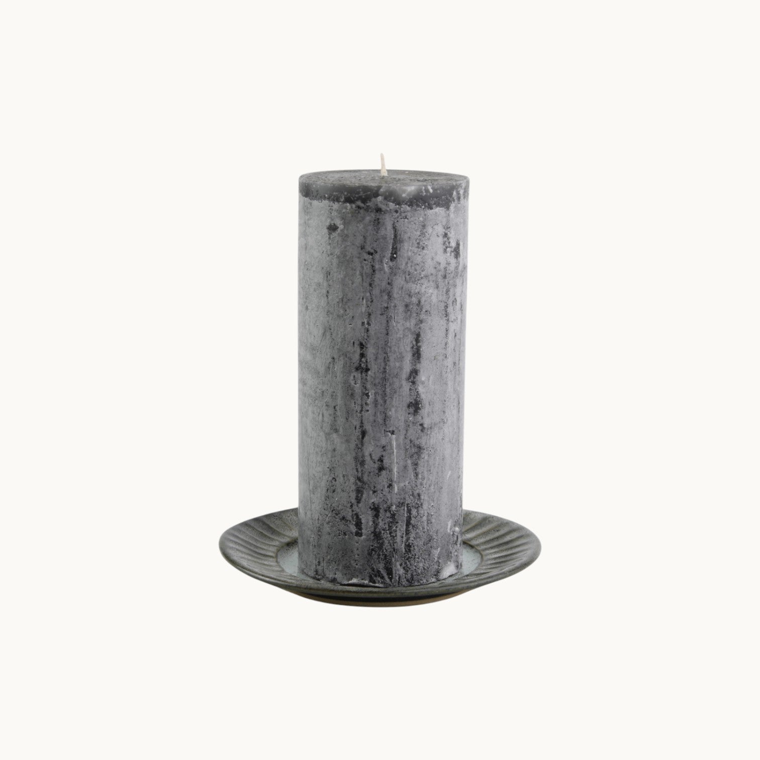 MANTRA LIVING charcoal frosted pillar candle with a textured wax finish on a small decorative plate #Color_Charcoal