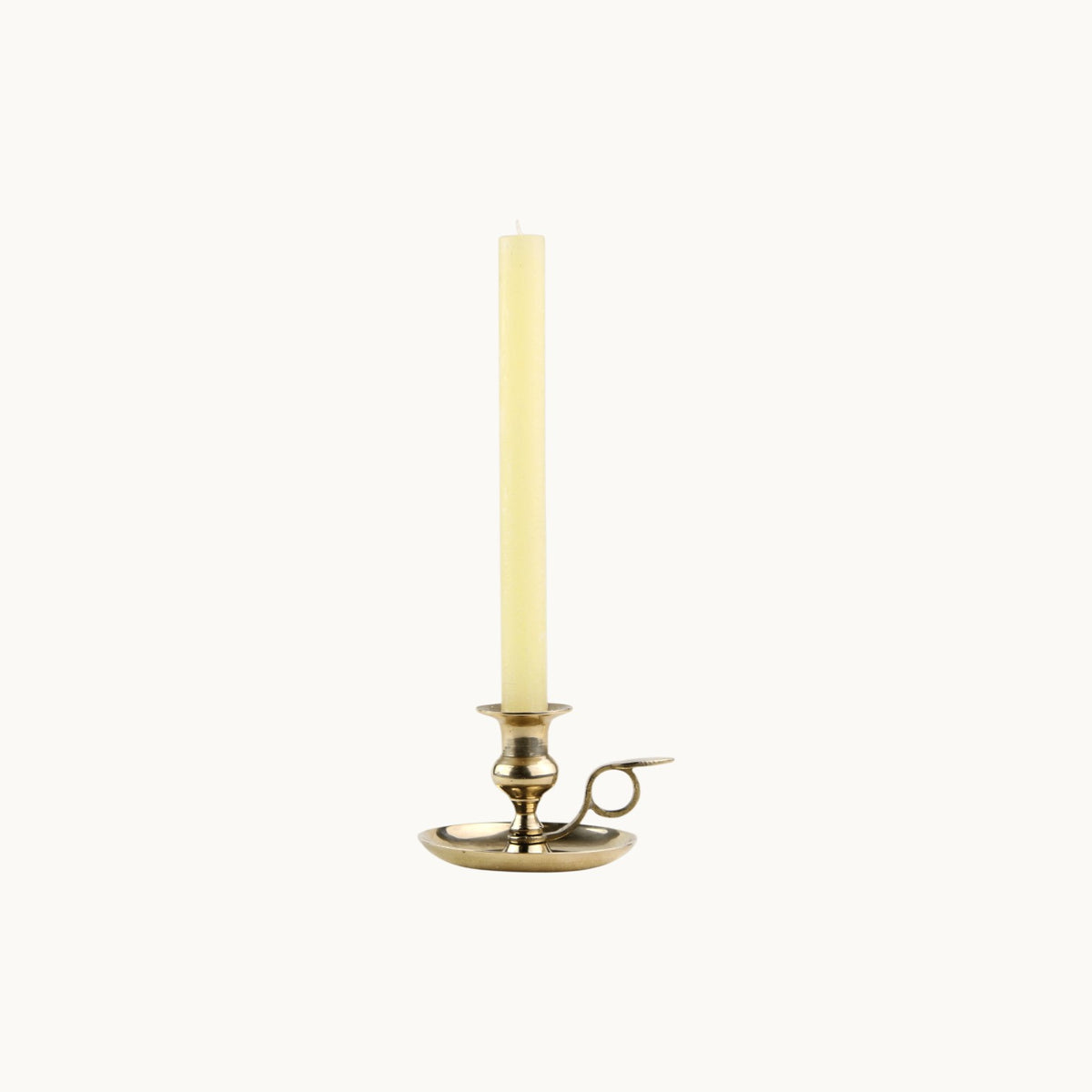 Mantra Living Frosted Dinner Candle in pastel yellow, a pale butter taper in a brass chamberstick holder. #Color_Pastel Yellow