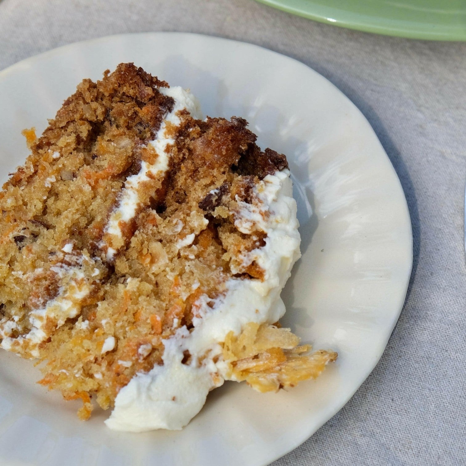 Mantra Living Daisy side plate in Almond holding a slice of carrot cake. #Color_Almond
