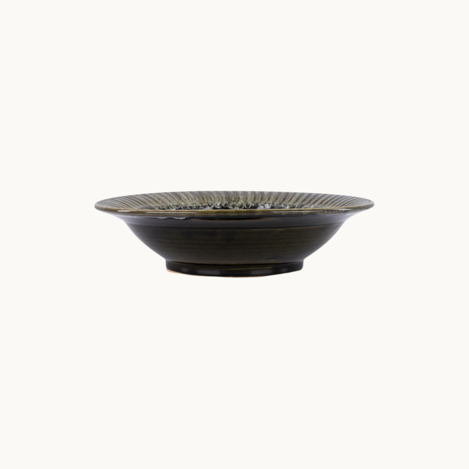 MANTRA LIVING handcrafted ceramic fluted centerpiece bowl in a dark glossy glaze, side view.