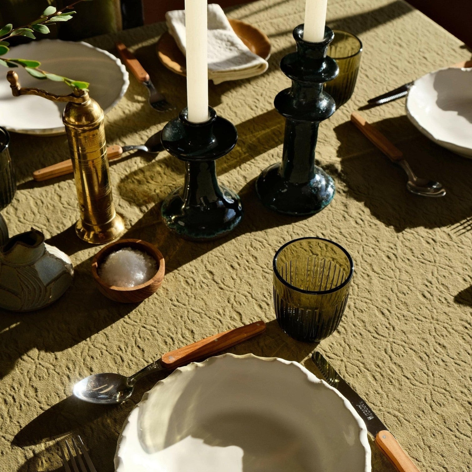 Mantra Living Hibiscus cotton tablecloth in pistachio dressing a long table set with candlesticks, green glassware and scalloped plates. #Color_Pistachio