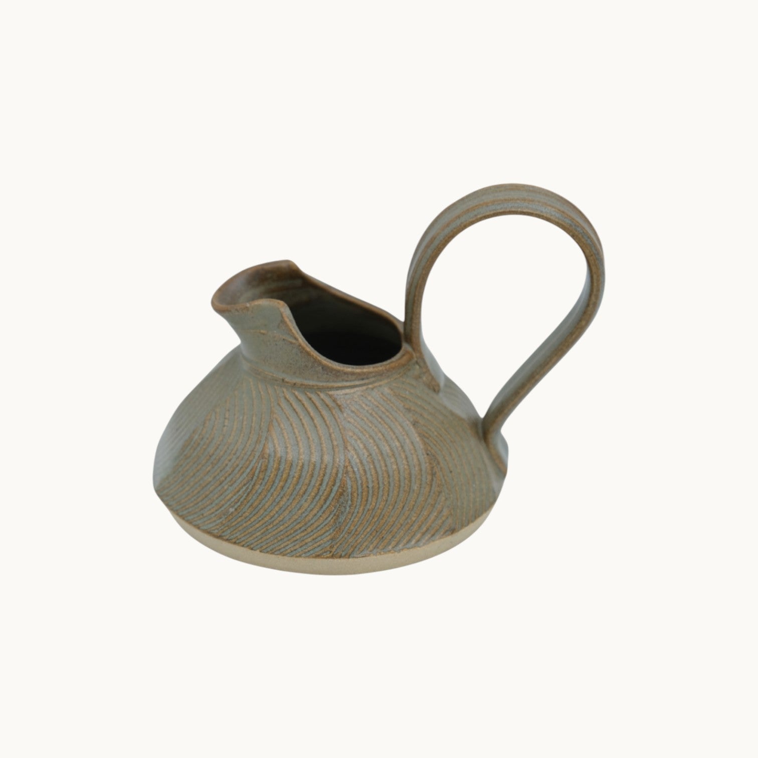 Mantra Living Small Ripple Jug in a soft sage glaze, showing the carved ripple texture and pouring lip.