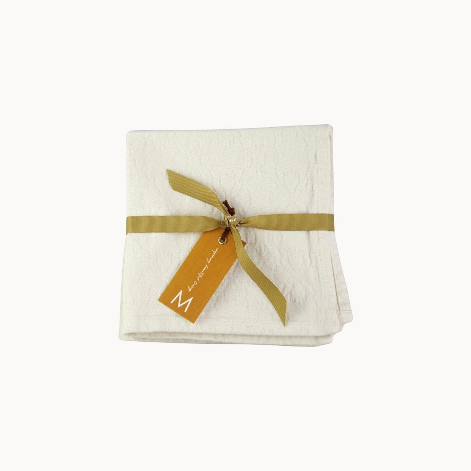 Mantra Living Hibiscus cotton napkins in vanilla, set of four folded jacquard napkins with a decorative ribbon tie. #Color_Vanilla