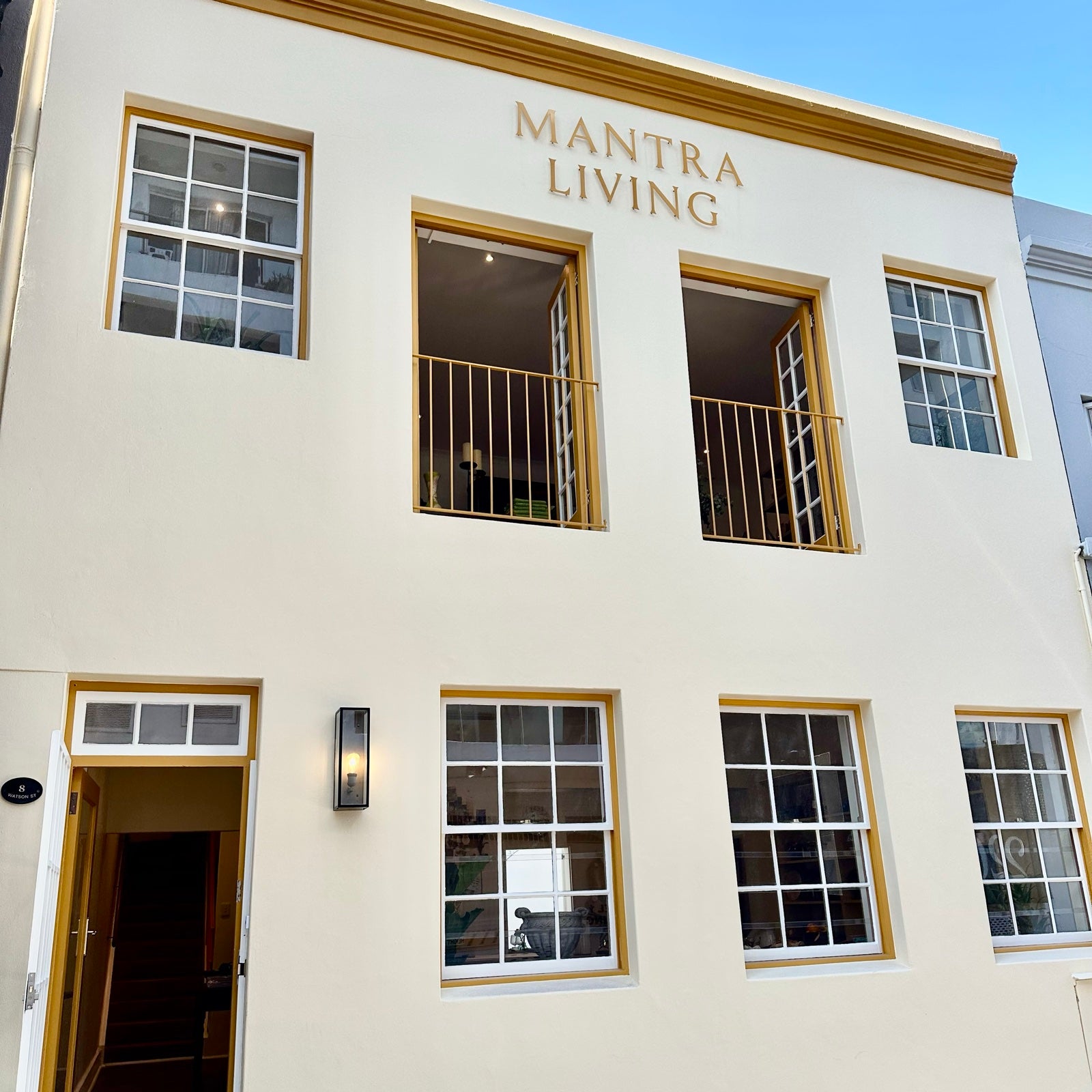 The Mantra Living shopfront at 8 Watson Street, a cream building with mustard window frames